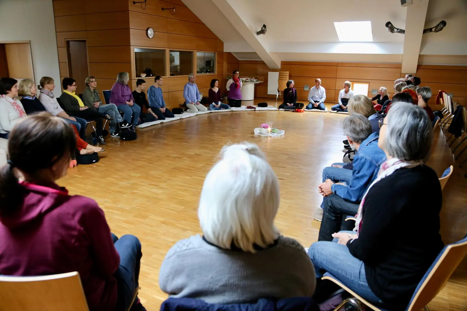 Meditationsgruppe übt gemeinsam die Übung der Stille in einem großen Saal in der Ortenau